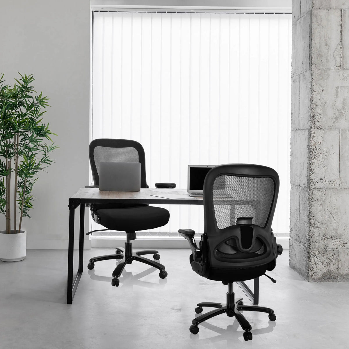To sorte XXL drejestole INSTRUCTOR SW I med mesh-ryg ved et skrivebord fra hjh OFFICE