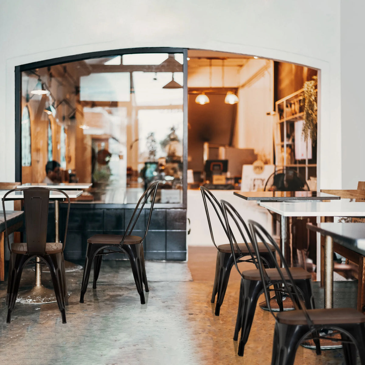 Sorte Bistrostole VANTAGGIO COMFORT W med metalstel ved borde i en café fra hjh OFFICE