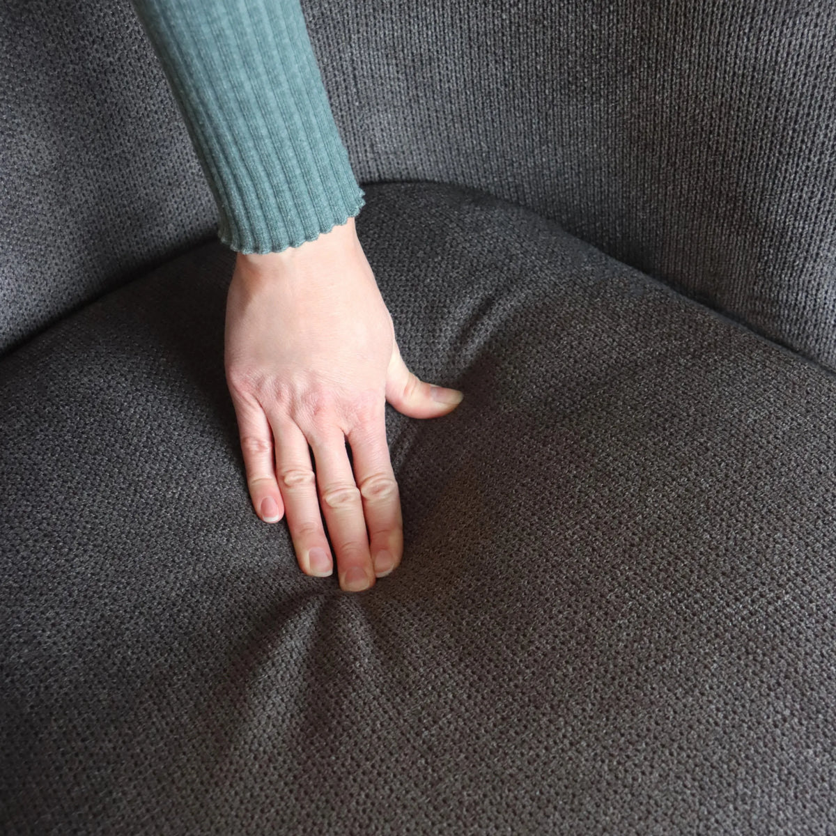 Gråt stofbetræk på sædet af HAYRIVER loungesofa under en hånd fra hjh LIVING