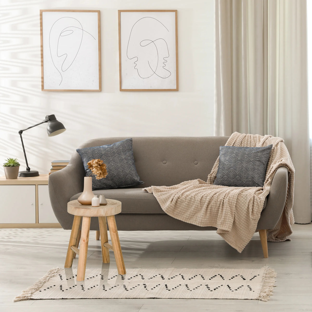 Brun RUSTIKO W skammel i træ som sidebord foran en grå sofa fra hjh LIVING