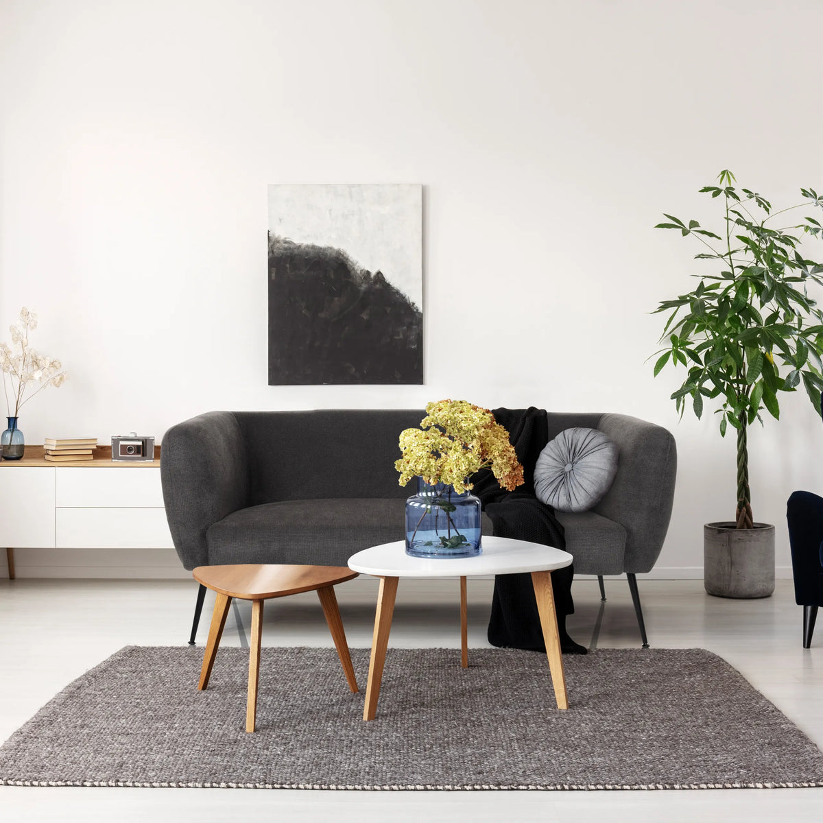 Grå loungesofa HAYRIVER med to sideborde og et tæppe i et lyst rum fra hjh LIVING