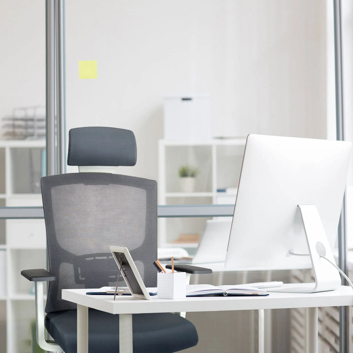 Grå Professionel kontorstol CAPTIVO BASE W med netryglæn og nakkestøtte ved et skrivebord fra hjh OFFICE