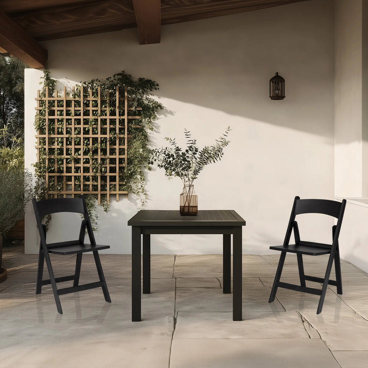 Zwei schwarze Outdoor-Stühle TRAVANO 1 mit passendem Tisch auf einer Terrasse von hjh LIVING