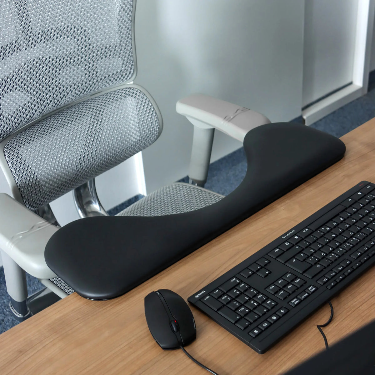 Sort RELEX RT2 armlæn på et skrivebord ved siden af et tastatur og en computermus fra hjh OFFICE