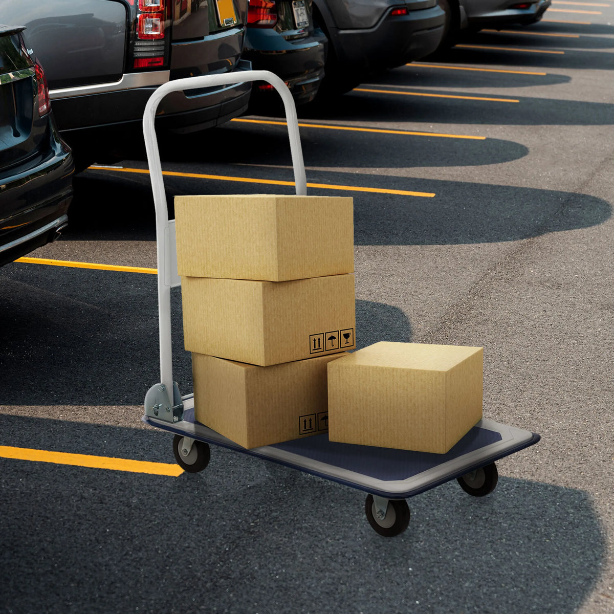 Blå-hvid platformsvogn CARRY med tre lastede papkasser på en parkeringsplads fra hjh OFFICE