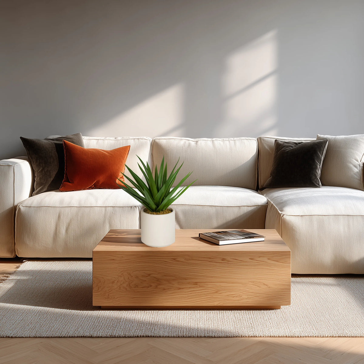 Kunstig plante Agave i grøn med hvid potte på et træbord foran en lys sofa fra hjh OFFICE