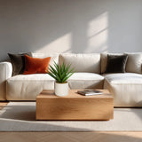 Kunstig plante Agave i grøn med hvid potte på et træbord foran en lys sofa fra hjh OFFICE
