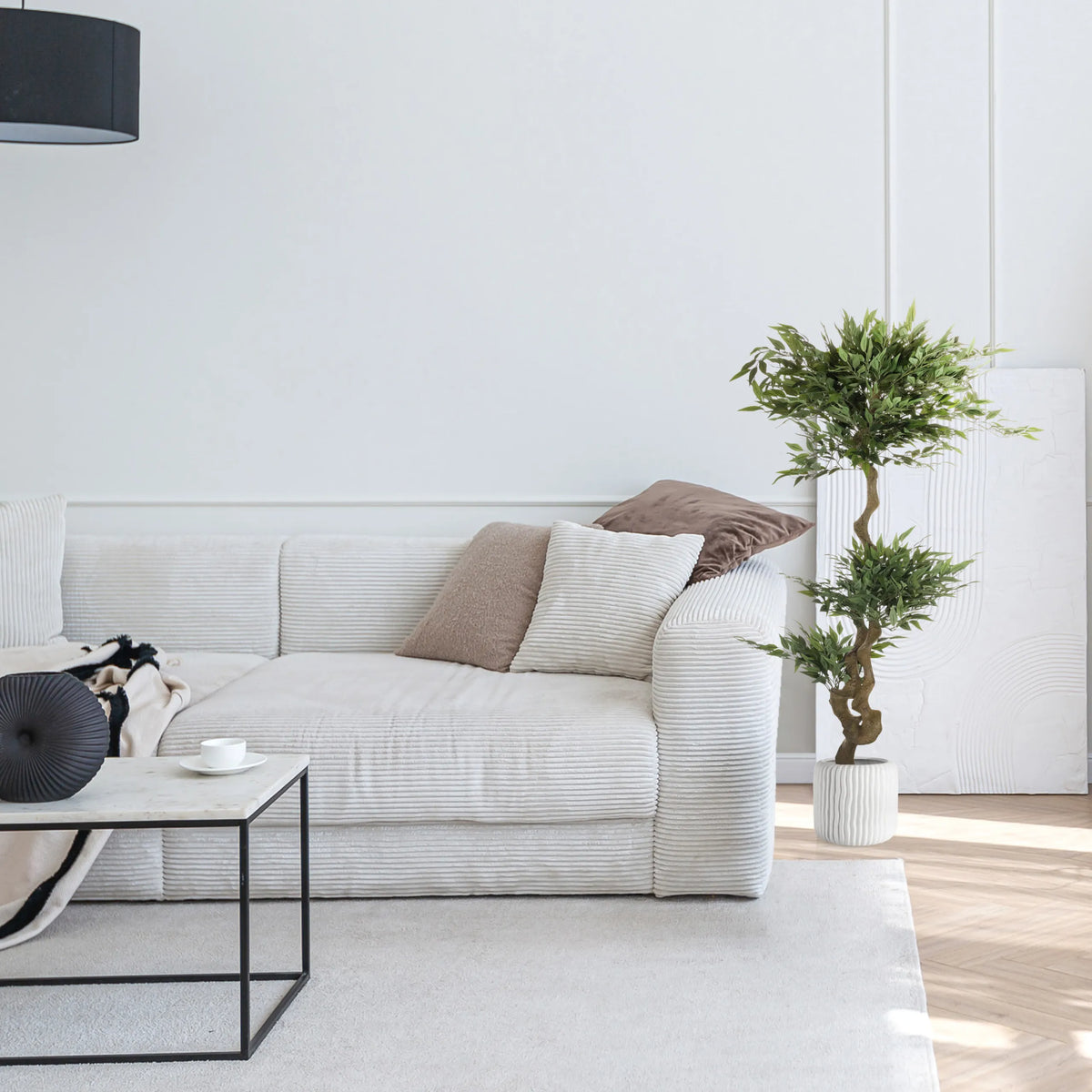 Grøn kunstige plante ACACIA i en hvid potte ved siden af en sofa fra hjh OFFICE