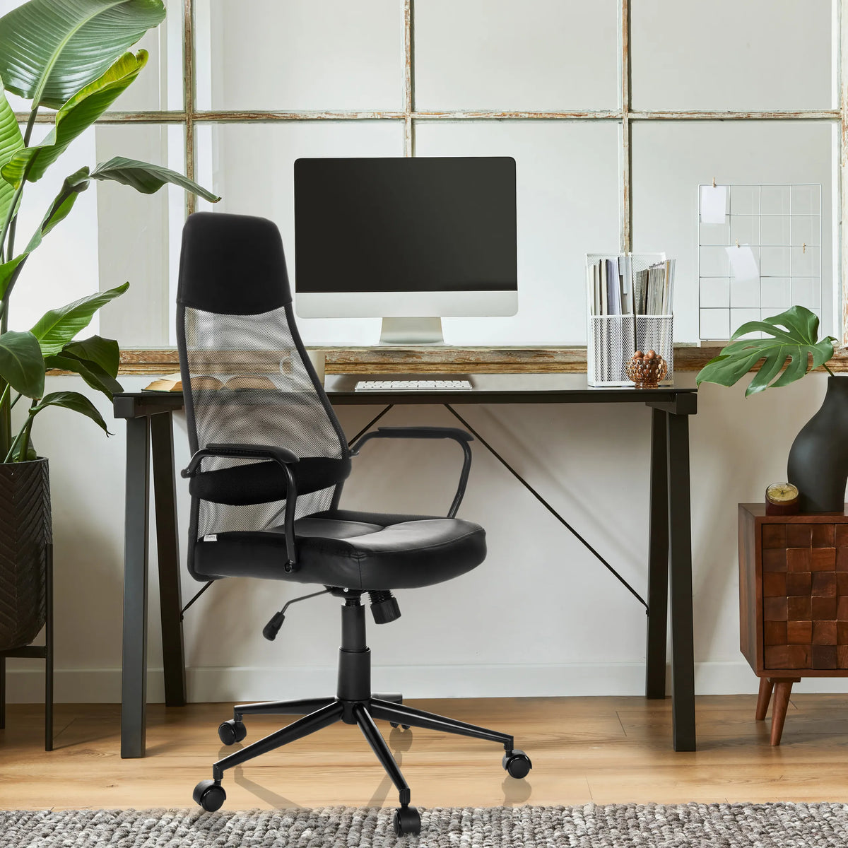 Sort MARCOZ Home Office chefstol med netryglæn og armlæn foran et skrivebord fra MyBuero