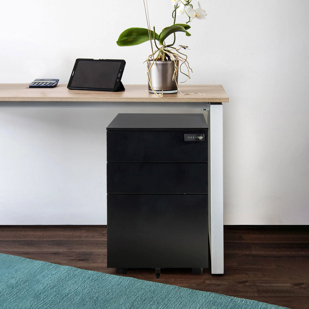 Sort rullecontainer i metal COLOR OS I med tre skuffer og hjul under et skrivebord fra hjh OFFICE