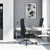 Profi-Chefsessel VITORO ECO in Schwarz mit hoher Rückenlehne und Fußkreuz vor einem weißen Schreibtisch von hjh OFFICE