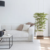 Grøn Kunstige plante BAMBUS I i en trækrukke ved siden af en hvid sofa fra hjh OFFICE