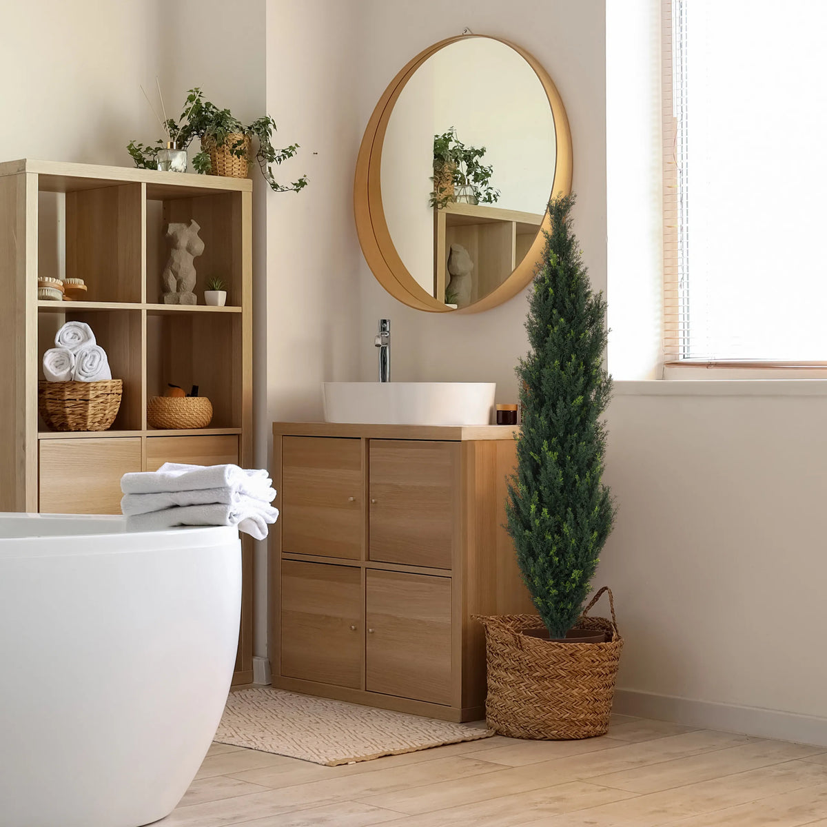 Grøn kunstige plante CEDRUS i en flettet kurv ved siden af et badeværelsesmøbel fra hjh OFFICE