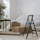 Sort Foldestige SOLID W6 med tre trin i et rum ved siden af flyttekasser fra hjh OFFICE