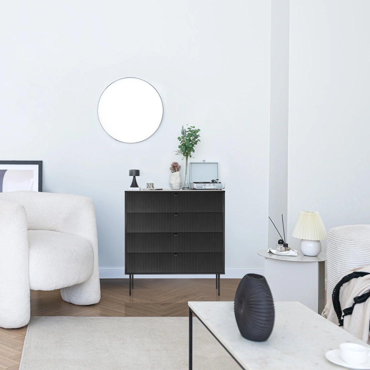 Sort kommode KARBY K med tre skuffer og slanke metalben i et lyst opholdsrum fra hjh LIVING