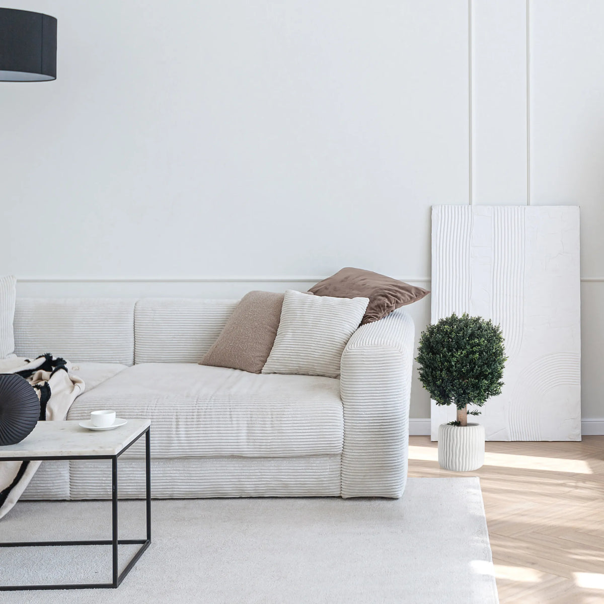 Grøn Kunstige plante BUXUS i en hvid potte ved siden af en sofa fra hjh OFFICE